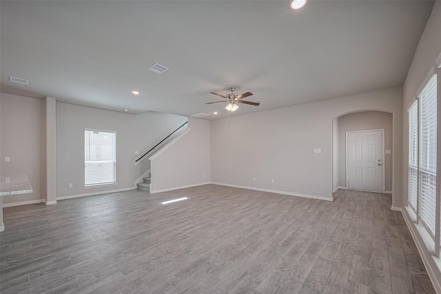 24711 Sonora Crescent Cir, Huffman, TX 77336 - unfurnished living room with wood finished floors, stairway, recessed lighting, ceiling fan, and arched walkways