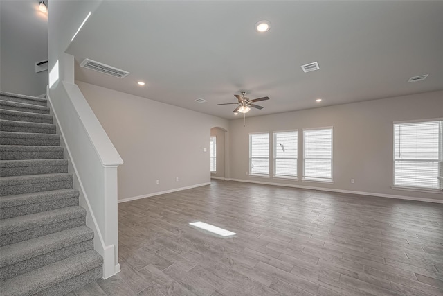 24711 Sonora Crescent Cir, Huffman, TX 77336 - unfurnished living room featuring ceiling fan, stairs, recessed lighting, arched walkways, and wood finished floors