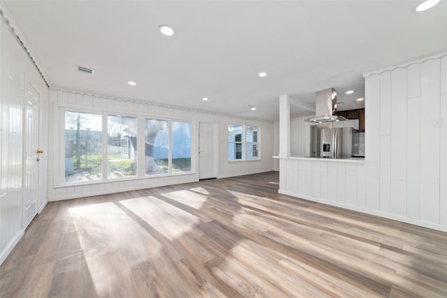 800 E Adoue St, Baytown, TX 77520 - unfurnished living room with a decorative wall, light wood-type flooring, and recessed lighting
