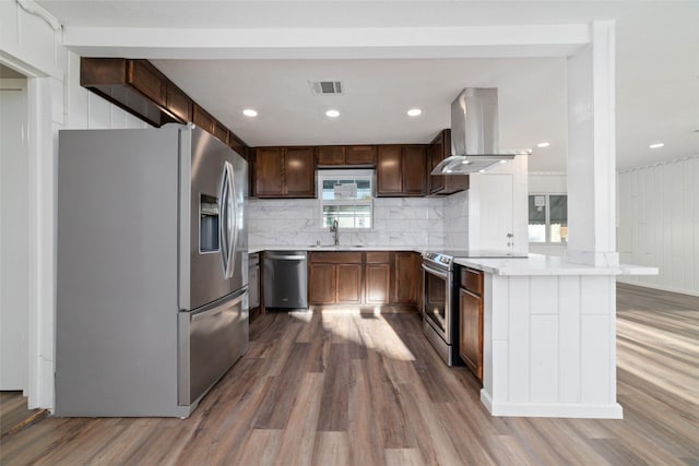 800 E Adoue St, Baytown, TX 77520 - kitchen featuring stainless steel appliances, island exhaust hood, dark wood finished floors, light countertops, and decorative backsplash