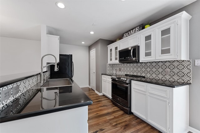 2623 Woodridge Cove Dr, Houston, TX 77087 - kitchen with stainless steel appliances, dark countertops, backsplash, white cabinetry, and recessed lighting