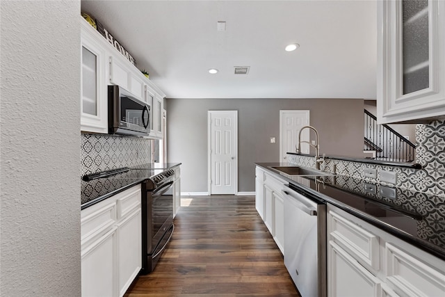 2623 Woodridge Cove Dr, Houston, TX 77087 - kitchen featuring appliances with stainless steel finishes, tasteful backsplash, dark wood finished floors, white cabinets, and glass insert cabinets