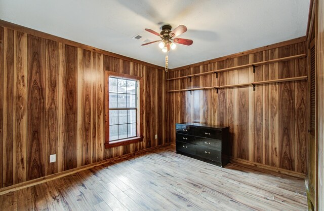 810 Roosevelt St, Sealy, TX 77474 - unfurnished bedroom featuring light wood-style flooring, wood walls, and a ceiling fan