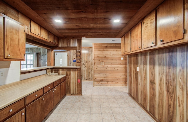 810 Roosevelt St, Sealy, TX 77474 - kitchen with wooden ceiling, light countertops, wooden walls, and brown cabinetry