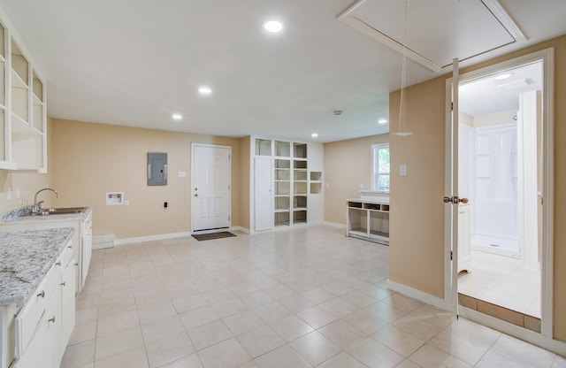 810 Roosevelt St, Sealy, TX 77474 - kitchen with electric panel, recessed lighting, light tile patterned floors, open shelves, and white cabinetry