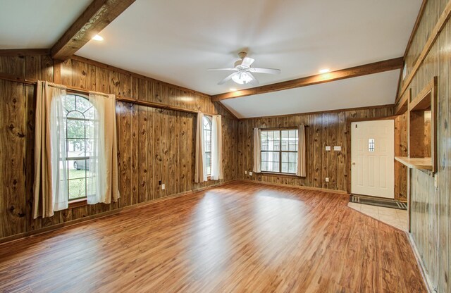 810 Roosevelt St, Sealy, TX 77474 - unfurnished living room with light wood finished floors, wooden walls, and a ceiling fan