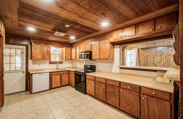 810 Roosevelt St, Sealy, TX 77474 - kitchen with dishwasher, black range with electric cooktop, stainless steel microwave, wood ceiling, and light countertops