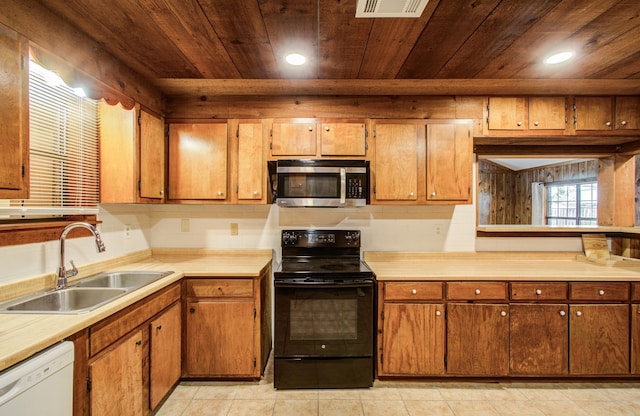 810 Roosevelt St, Sealy, TX 77474 - kitchen featuring stainless steel microwave, black range with electric stovetop, white dishwasher, wood ceiling, and light countertops