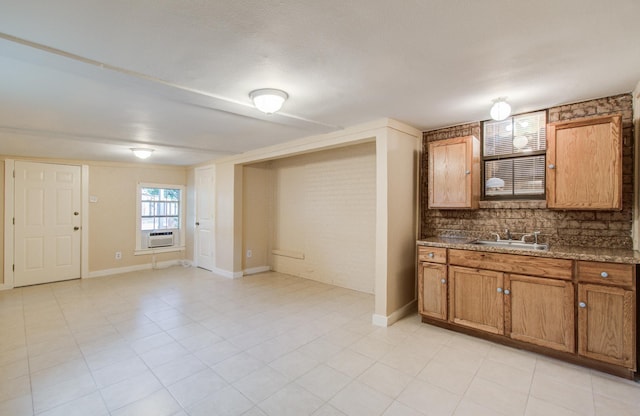 810 Roosevelt St, Sealy, TX 77474 - kitchen featuring cooling unit, brown cabinetry, light tile patterned floors, and stone counters