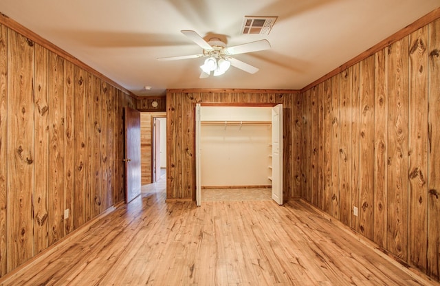 810 Roosevelt St, Sealy, TX 77474 - unfurnished bedroom with wood walls, light wood-style flooring, a closet, and a ceiling fan