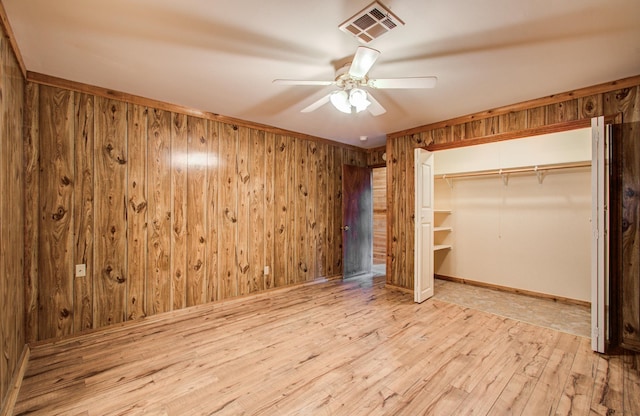 810 Roosevelt St, Sealy, TX 77474 - unfurnished bedroom with wood-type flooring, wooden walls, a closet, and a ceiling fan