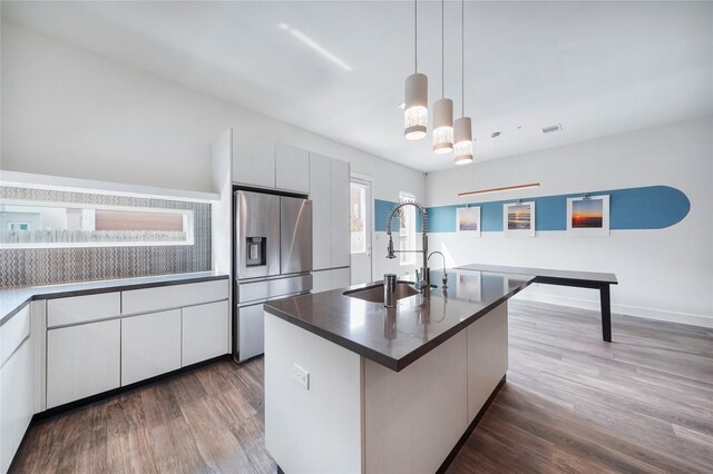 5509 Paraiso Pl, Houston, TX 77091 - kitchen featuring stainless steel fridge, modern cabinets, wood finished floors, dark countertops, and pendant lighting