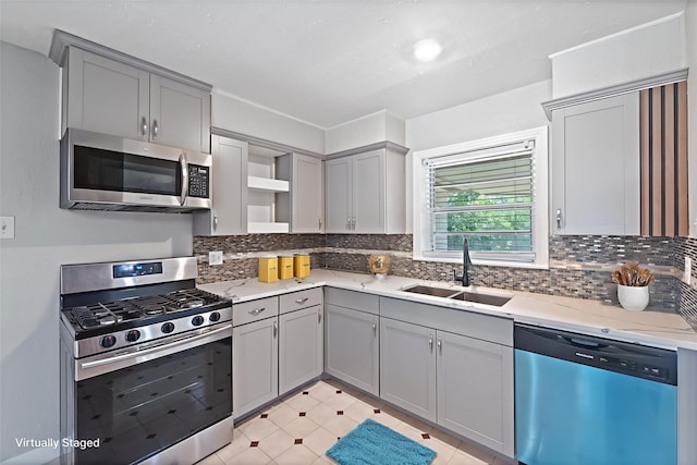 4517 W 43rd St, Houston, TX 77092 - kitchen with appliances with stainless steel finishes, gray cabinets, open shelves, decorative backsplash, and light stone counters