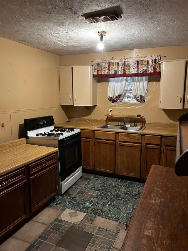 7214 Schuller Rds, Houston, TX 77093 - kitchen with black gas range, a textured ceiling, and light countertops