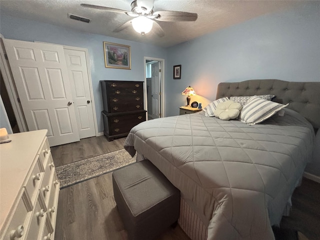 813 Camelot Ln, Friendswood, TX 77546 - bedroom with dark wood-type flooring, a textured ceiling, and a ceiling fan