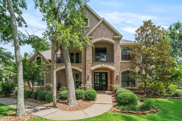 52 Tall Trl, Missouri City, TX 77459 - french country style house with french doors, brick siding, a balcony, and a front lawn