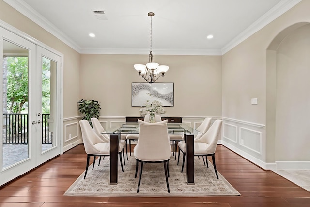 52 Tall Trl, Missouri City, TX 77459 - dining room featuring wood-type flooring, a chandelier, arched walkways, crown molding, and a wainscoted wall