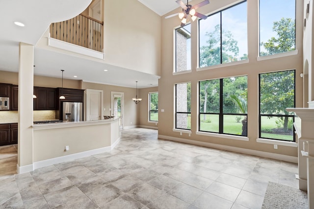 52 Tall Trl, Missouri City, TX 77459 - unfurnished living room featuring a ceiling fan, a towering ceiling, a chandelier, recessed lighting, and light tile patterned floors