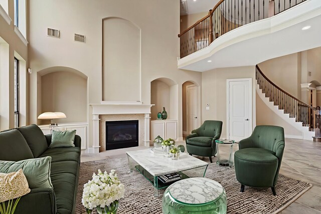 52 Tall Trl, Missouri City, TX 77459 - living area featuring a towering ceiling, stairs, and a glass covered fireplace