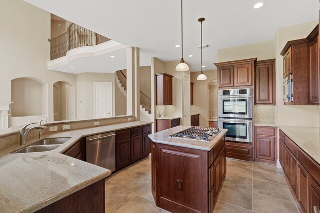 52 Tall Trl, Missouri City, TX 77459 - kitchen with appliances with stainless steel finishes, a center island, light stone countertops, pendant lighting, and recessed lighting
