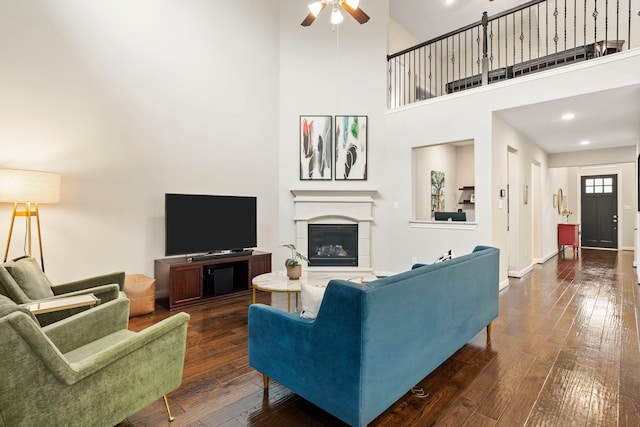 10118 Cypress Path, Missouri City, TX 77459 - living room featuring ceiling fan, a high ceiling, dark wood-type flooring, a glass covered fireplace, and recessed lighting