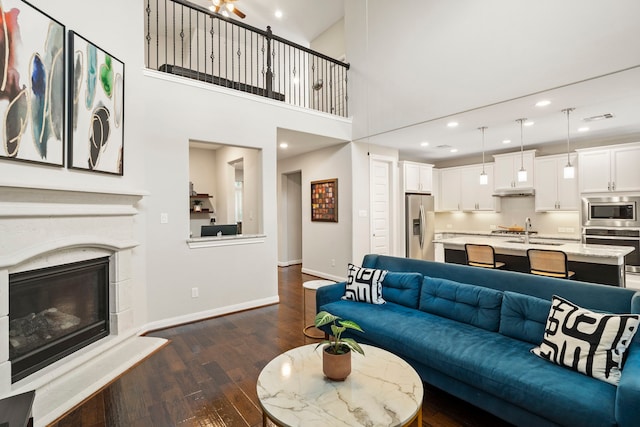 10118 Cypress Path, Missouri City, TX 77459 - living area featuring dark wood-style floors, a fireplace, recessed lighting, and a high ceiling
