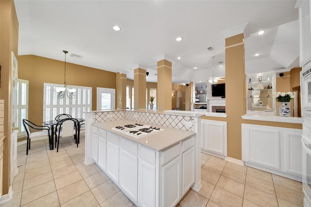 22710 Sierra Lake Ct, Katy, TX 77494 - kitchen featuring white gas cooktop, a ceiling fan, lofted ceiling, a kitchen island, and light countertops