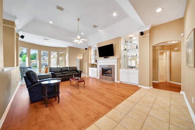 22710 Sierra Lake Ct, Katy, TX 77494 - living room with a ceiling fan, a fireplace, arched walkways, built in features, and light wood-type flooring