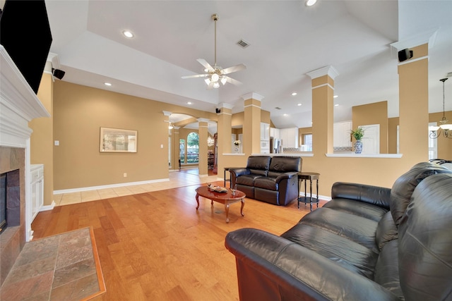 22710 Sierra Lake Ct, Katy, TX 77494 - living room featuring ornate columns, ceiling fan, a tiled fireplace, light wood-style flooring, and recessed lighting