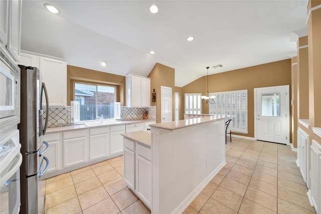 22710 Sierra Lake Ct, Katy, TX 77494 - kitchen featuring freestanding refrigerator, tasteful backsplash, oven, a kitchen island, and a chandelier