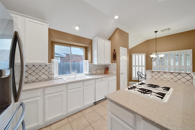 22710 Sierra Lake Ct, Katy, TX 77494 - kitchen with white appliances, backsplash, a chandelier, vaulted ceiling, and light countertops