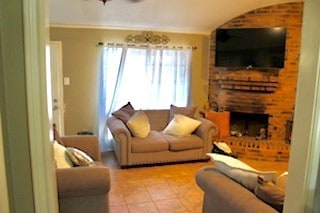 5923 Pine Needle Ln, Pasadena, TX 77505 - living area with a brick fireplace, vaulted ceiling, and tile patterned flooring