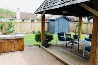 5923 Pine Needle Ln, Pasadena, TX 77505 - fenced backyard with a storage unit and a wooden deck