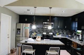 5923 Pine Needle Ln, Pasadena, TX 77505 - kitchen featuring stainless steel appliances, a center island, tasteful backsplash, a kitchen breakfast bar, and dark cabinetry