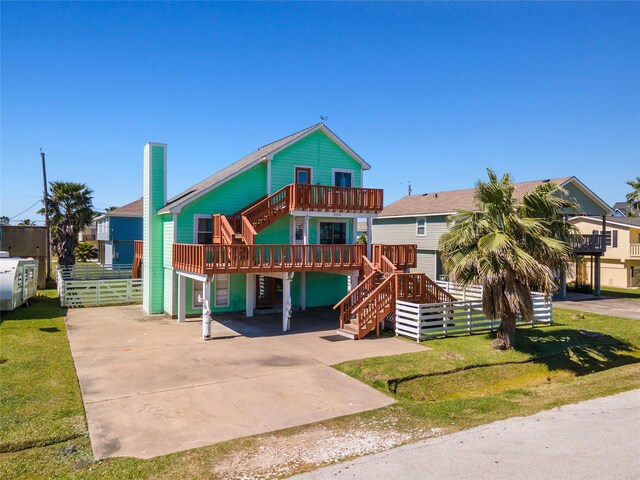 4034 Reeves Dr, Galveston, TX 77554 - coastal home featuring stairs, concrete driveway, a carport, and a deck