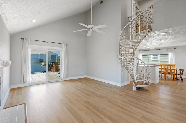 4034 Reeves Dr, Galveston, TX 77554 - unfurnished living room with wood finished floors, a textured ceiling, a ceiling fan, recessed lighting, and high vaulted ceiling