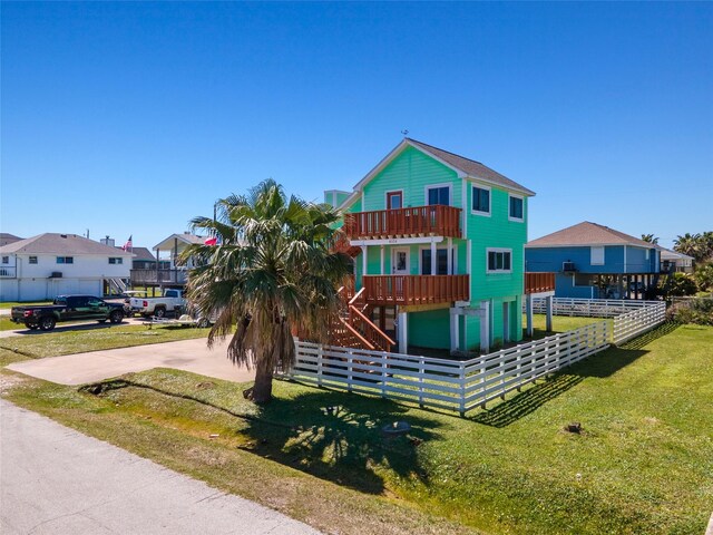 4034 Reeves Dr, Galveston, TX 77554 - view of front facade featuring a balcony, stairs, driveway, and a residential view