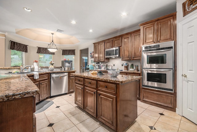 305 Pinnacle Cove Ct, League City, TX 77573 - kitchen with appliances with stainless steel finishes, a kitchen island, light tile patterned floors, stone countertops, and recessed lighting