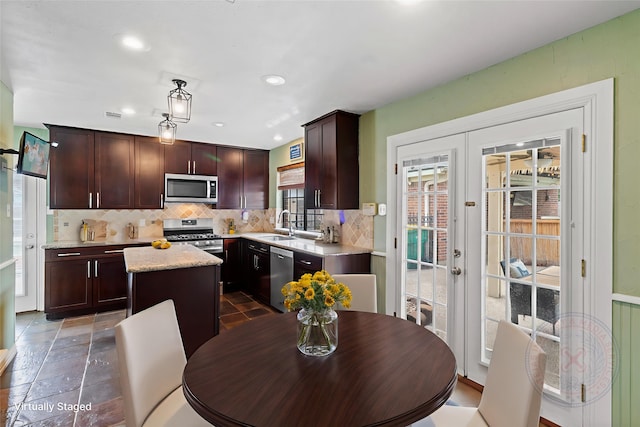 2802 Sandpebble Dr, Seabrook, TX 77586 - kitchen featuring stainless steel appliances, a kitchen island, backsplash, french doors, and dark brown cabinetry