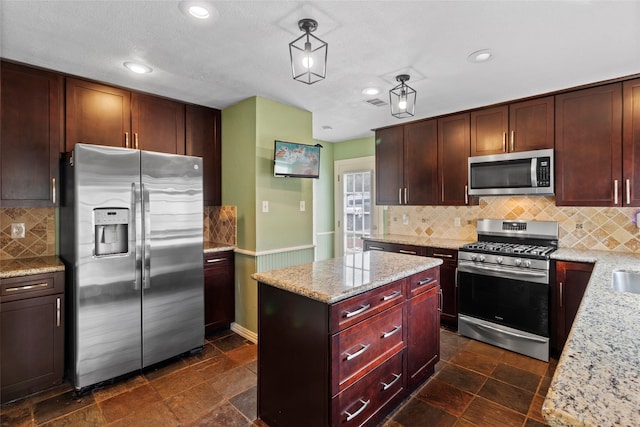 2802 Sandpebble Dr, Seabrook, TX 77586 - kitchen with stainless steel appliances, a kitchen island, light stone counters, backsplash, and recessed lighting