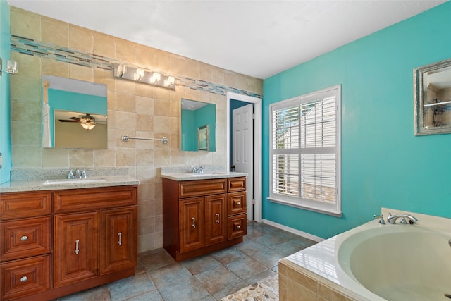 2802 Sandpebble Dr, Seabrook, TX 77586 - bathroom with tile walls, two vanities, a garden tub, and ceiling fan