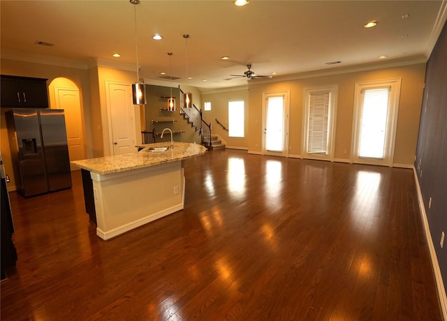 12248 Oxford Crescent Cir, Houston, TX 77082 - kitchen with stainless steel refrigerator with ice dispenser, ornamental molding, arched walkways, recessed lighting, and a kitchen island with sink
