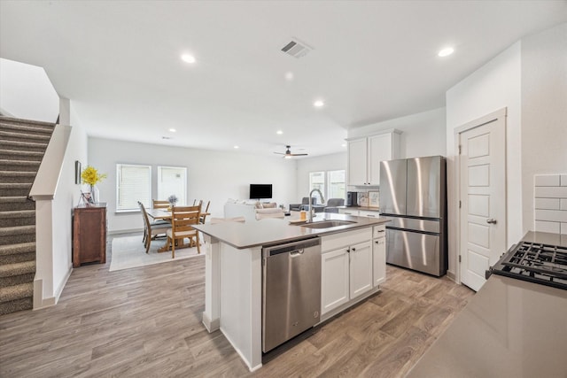 7714 Cattleman Valley Dr, Rosharon, TX 77583 - kitchen with appliances with stainless steel finishes, an island with sink, open floor plan, white cabinets, and recessed lighting