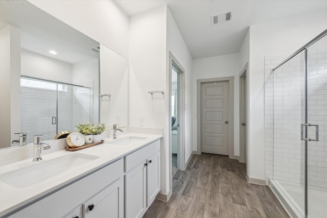7714 Cattleman Valley Dr, Rosharon, TX 77583 - bathroom featuring double vanity, wood finished floors, a shower stall, and recessed lighting