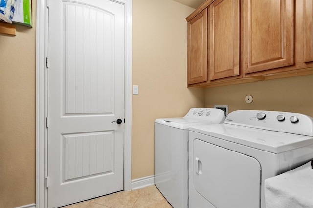 10010 Friesian Estates Dr, Spring, TX 77379 - laundry area featuring washing machine and clothes dryer, cabinet space, and light tile patterned floors