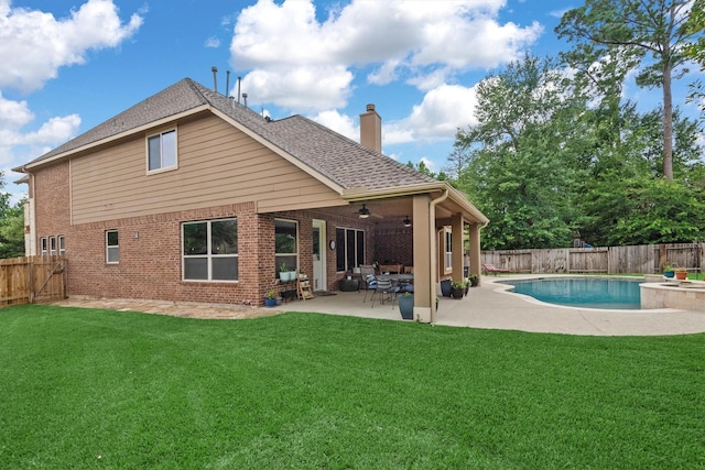 10010 Friesian Estates Dr, Spring, TX 77379 - back of property featuring a chimney, a fenced backyard, a ceiling fan, a patio area, and brick siding