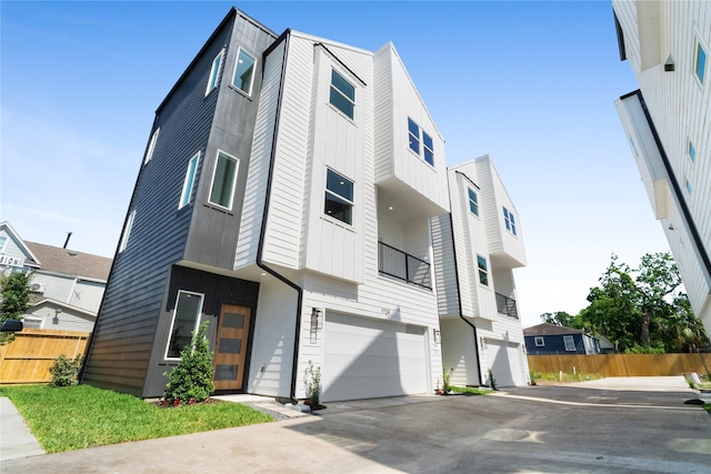 1124 Hogan St, Houston, TX 77009 - view of front facade with a garage, board and batten siding, and driveway
