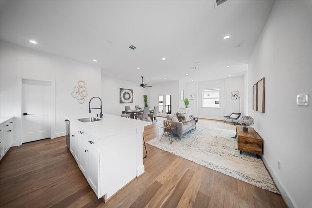 1124 Hogan St, Houston, TX 77009 - kitchen with white cabinetry, wood finished floors, ceiling fan, light countertops, and recessed lighting