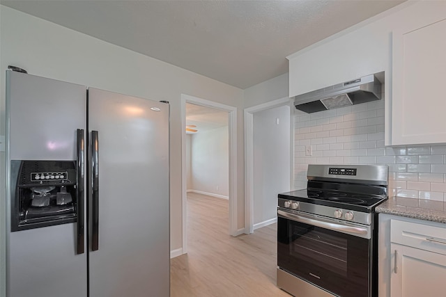 2401 33rd Ave N, Texas City, TX 77590 - kitchen with stainless steel appliances, wall chimney range hood, white cabinets, light stone countertops, and decorative backsplash