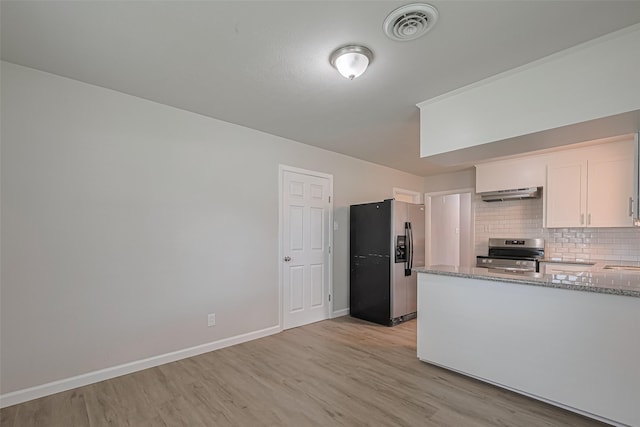 2401 33rd Ave N, Texas City, TX 77590 - kitchen with appliances with stainless steel finishes, under cabinet range hood, light wood finished floors, and stone counters